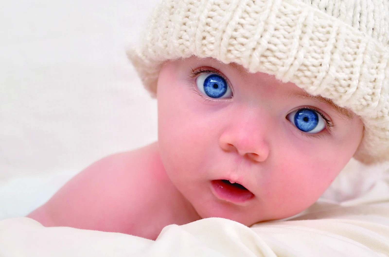 Bebé de ojos azules con gorrito tejido, fotografía completa sin recorte del rostro
